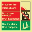 Nødskilt: I tilfelle brann, bruk trappen. Etterlysende/selvlysende nødskilt som tydelig informerer på norsk og engelsk at i tilfelle brann må ikke heisen brukes. Bruk trappen.