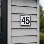 Klassisk hvitt husnummer skilt - husskilt i aluminium med tall. Skrues på husvegg.